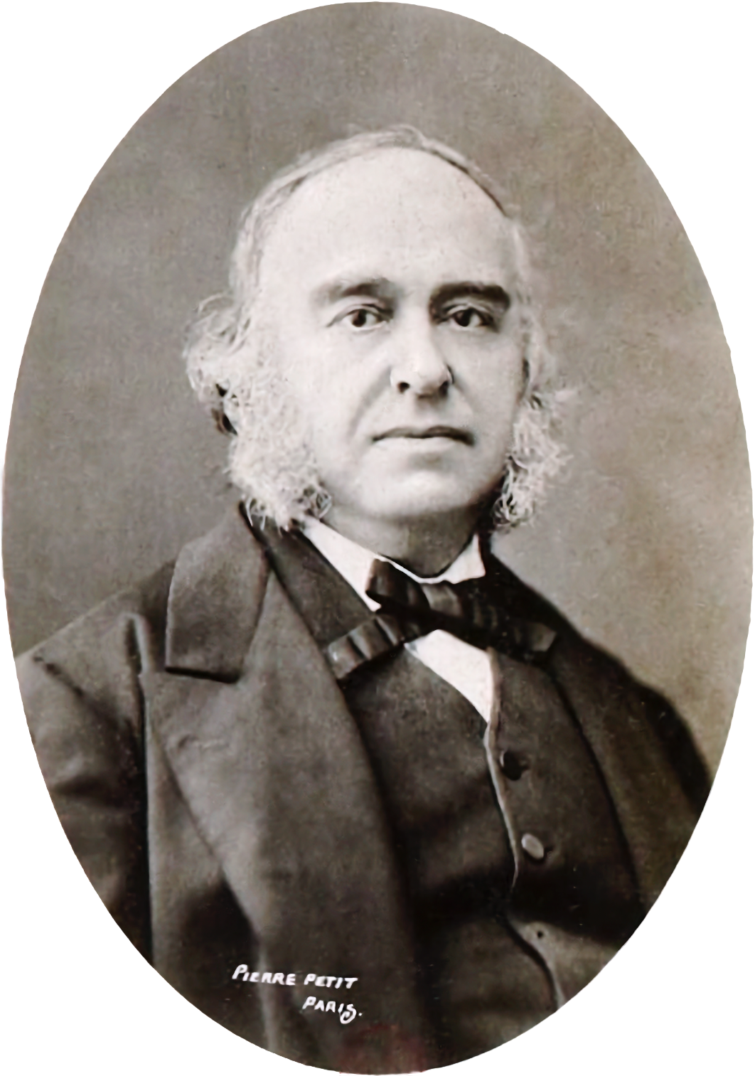 A nineteenth-century studio photograph of a bearded man in a dark coat, seated and facing slightly away.