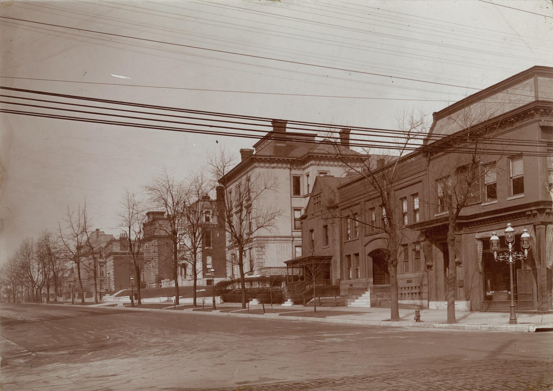 An early twentieth-century street corner with a Berlitz School of Languages sign on the building.