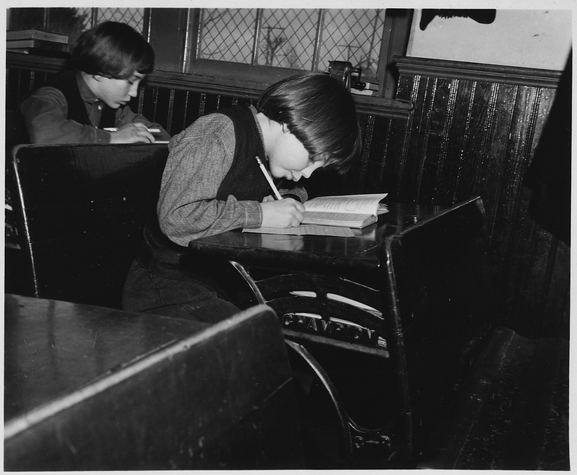Pupils of several ages seated together in a single-room country school.