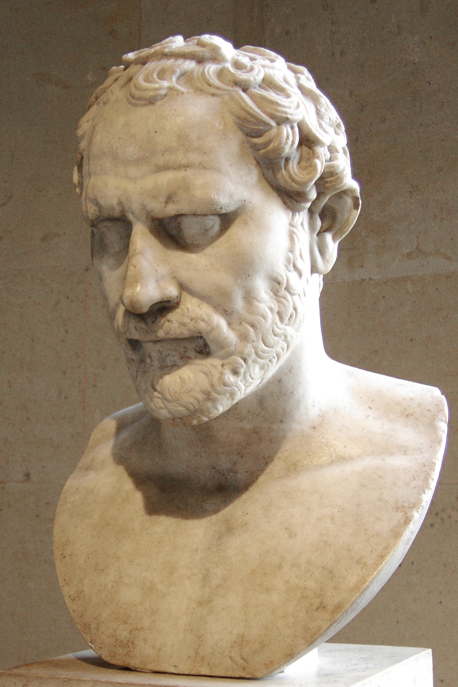 A marble statue of an orator standing with his hands clasped in front of him.