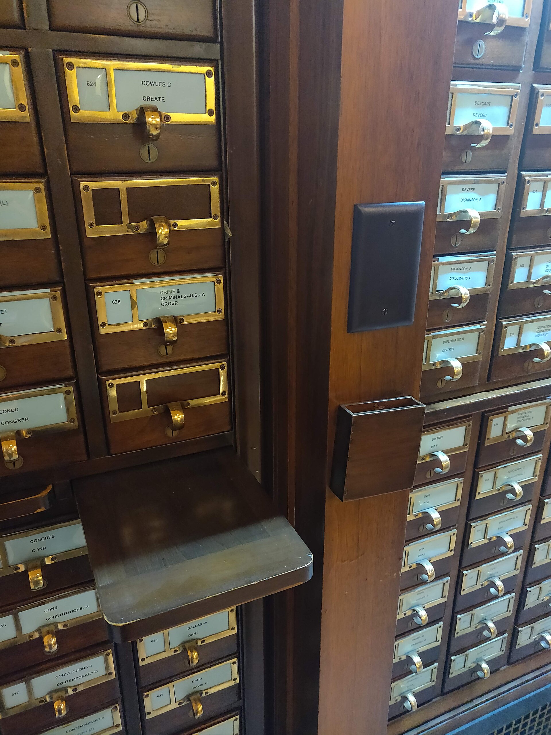 A library card catalogue cabinet, a wall of small labelled drawers.