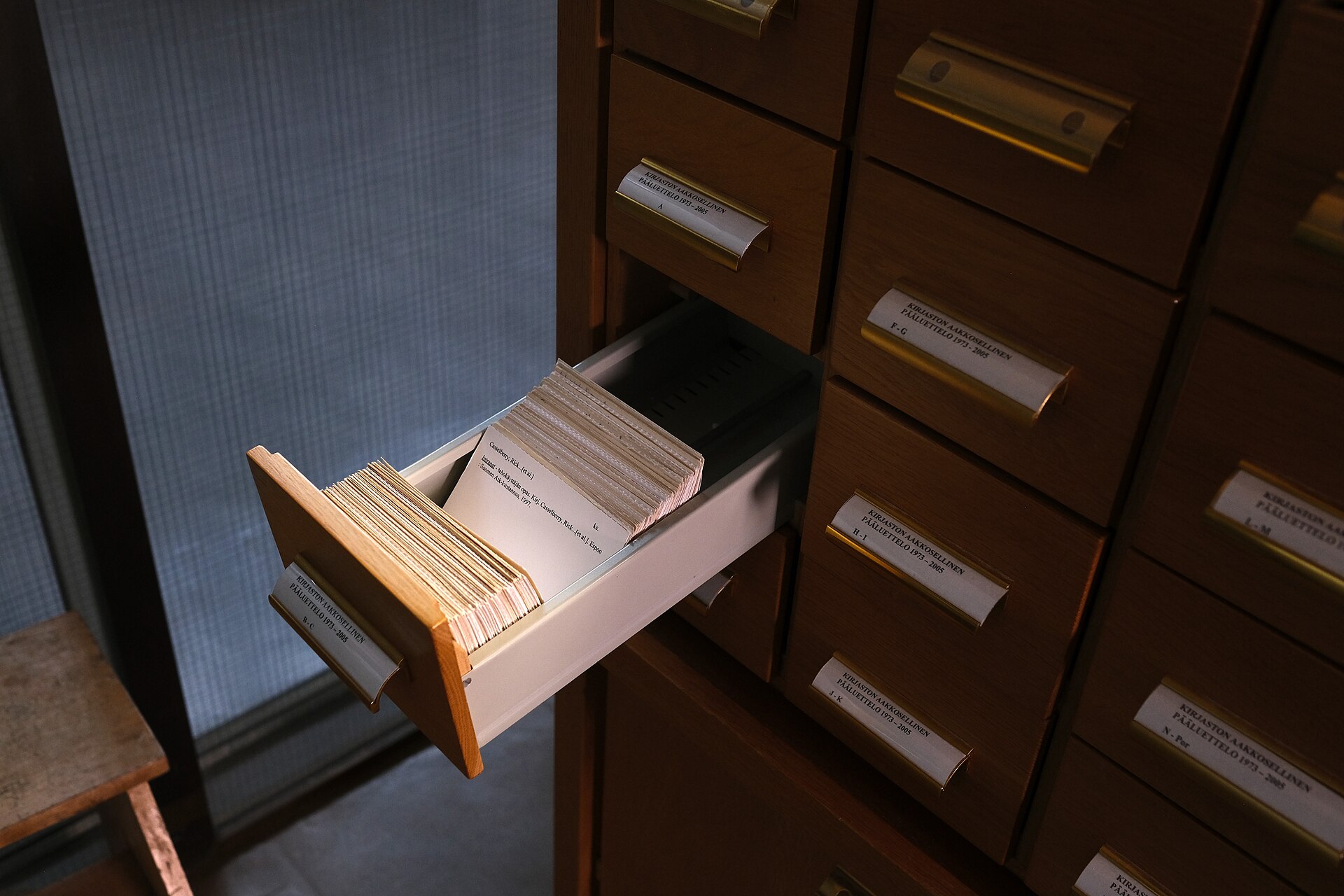 A wall of small wooden card-index drawers in an archive reading room.