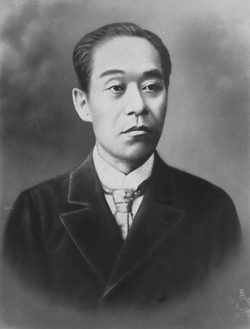 A studio photograph of a Meiji-era Japanese scholar in formal dress.
